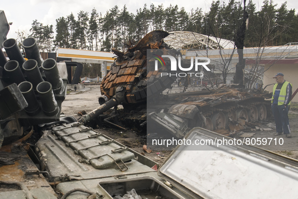 A road worker inspected destroyed Russian military tank on the highway Kyiv-Zhytomyr,  close to Kyiv, Ukraine, Monday, April 11, 2022 