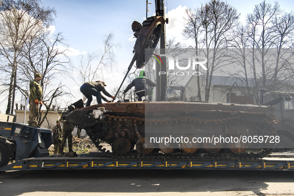 Workers remove destroyed Russian military tank  from the road near Andriyivka village, close to Kyiv, Ukraine, Monday, April 11, 2022 