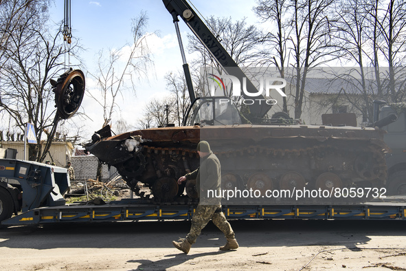 Workers remove destroyed Russian military tank  from the road near Andriyivka village, close to Kyiv, Ukraine, Monday, April 11, 2022 