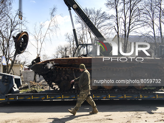 Workers remove destroyed Russian military tank  from the road near Andriyivka village, close to Kyiv, Ukraine, Monday, April 11, 2022 (