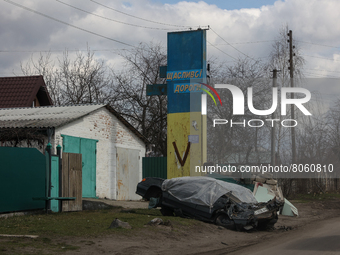 The wrecks of civilian vehicle are seen under sign with russian military 