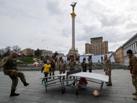KYIV, UKRAINE - APRIL 12, 2022 - Soldiers of the Pechersk Territorial Defence unit play teqball in Maidan Nezalezhnosti (Independence Square...