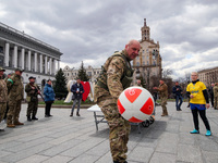 KYIV, UKRAINE - APRIL 12, 2022 - Soldiers of the Pechersk Territorial Defence unit play teqball in Maidan Nezalezhnosti (Independence Square...