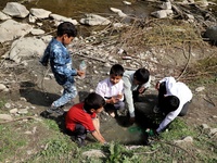 Students fill bottles with unhygienic water from a spring outside their school in Rafiabad, Baramulla, Jammu and Kashmir, India on 12 April...