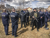 French forensics investigators, who arrived to Ukraine for the investigation of war crimes amid Russia's invasion, stand next to a mass grav...
