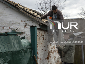 Men repair the roof of the house after the artillery shelling in the village of Andriyivka, Kyiv region, on April 12, 2022. 
About a month l...
