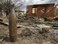 An artillery shell stands against the background of a destroyed house in the village of Andriyivka, Kyiv region, on April 12, 2022. 
About a...