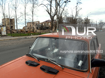 KYIV REGION, UKRAINE - APRIL 12, 2022 - A car with traces of shelling by the russian troops on the windshields is seen against the destroyed...