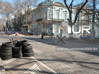 An Ukrainian citizen is seen passing in front of barricades made of tires, iron structures and cement blocks, in the streets of the center i...