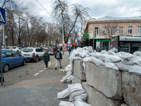 Ukrainian citizens are seen passing in front of barricades made of cement blocks and sand bags, in the streets of the center in Odessa, Ukra...