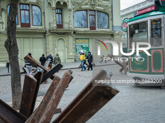 Ukrainian citizens are seen passing close to iron structures placed on the streets of the center in Odessa, Ukraine. (