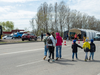 Ukrainian refugees are seen walking on the way to the tent where to receive water and food fron volunteers, on the Ukrainian side of the bor...
