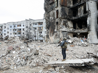 A military man patrols at the ruins of buildings destroyed by Russian shelling, amid Russia's Invasion of Ukraine, in Borodyanka, Kyiv regio...