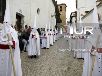 Penitents dressed in white from the Aurora Brotherhood during the Maundy Thursday in Granada, Spain, on April 14, 2022.Holy Week returns to...
