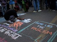 A protestor draws an illustration on road during a demonstration against rise in hate crimes and anti-Muslim violence in New Delhi, India on...