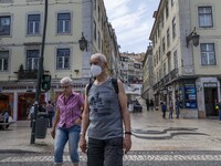 People wearing protective masks are seen walking around Rossio square. Lisbon, 17 April 2022. Covid-19 deaths in Portugal are stabilising, b...