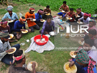 A group of workers eat their lunch as they take a break from harvesting paddy at a field Ashulia near Dhaka, Bangladesh, on April 18, 2022 (