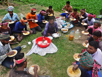 A group of workers eat their lunch as they take a break from harvesting paddy at a field Ashulia near Dhaka, Bangladesh, on April 18, 2022 (