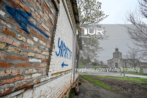 VESELIANKA, UKRAINE - APRIL 20, 2022 - A sign painted on the wall of a shop hit by a Russian shell points to a bomb shelter, Veselianka, Zap...