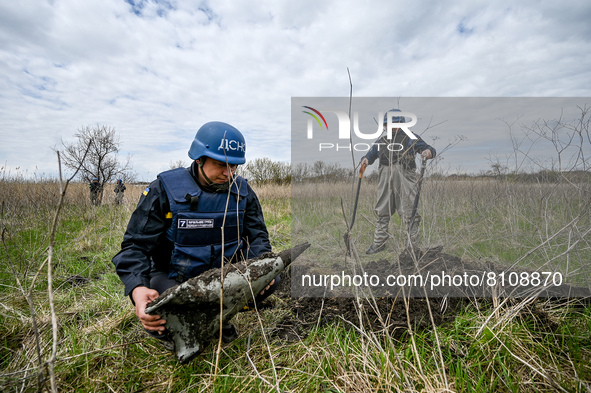 HRYHORIVKA, UKRAINE - APRIL 20, 2022 - An expert of a State Emergency Service bomb squad holds the remains of an Uragan rocket stuck in past...