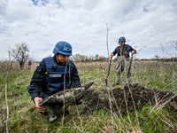 HRYHORIVKA, UKRAINE - APRIL 20, 2022 - An expert of a State Emergency Service bomb squad holds the remains of an Uragan rocket stuck in past...