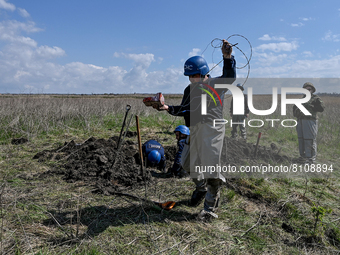 HRYHORIVKA, UKRAINE - APRIL 20, 2022 - An expert of a State Emergency Service bomb squad rolls out the wire during an effort to dispose of t...