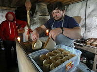 BUCHA, UKRAINE - APRIL 21, 2022 - Owner of the Khatynka pekaria (Baker's Hut) craft bakery Yaroslav Burkivskyi (R) joined by Polish voluntee...