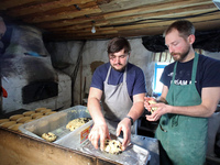 BUCHA, UKRAINE - APRIL 21, 2022 - Owner of the Khatynka pekaria (Baker's Hut) craft bakery Yaroslav Burkivskyi (L) joined by Polish voluntee...