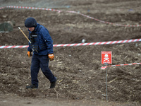 KYIV REGION, UKRAINE - APRIL 21, 2022 - An EOD expert of the State Emergency Service searches for explosives in the field during a mine clea...