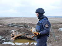 KYIV REGION, UKRAINE - APRIL 21, 2022 - An EOD expert of the State Emergency Service carries a shell during a mine clearance mission near Be...