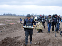 KYIV REGION, UKRAINE - APRIL 21, 2022 - An EOD expert of the State Emergency Service carries a shell during a mine clearance mission near Be...