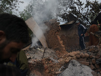 People assess the damaged residential house after an encounter between Indian forces and Militants came to end in Baramullah district of Ind...