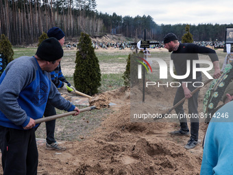 IRPIN, UKRAINE - APRIL 20, 2022 - Men install a cross at the grave of Territorial Defence serviceman Viktor Koval, 48, who died from a Russi...