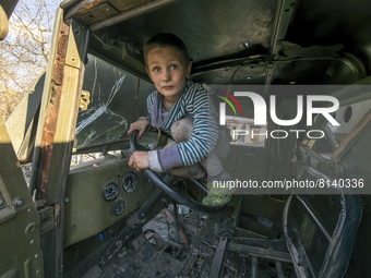 Local boy Faddei plays in a destroyed Russian military truck in Lukashivka village, Chernihiv area, April 27, 2022. (