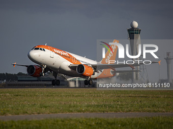 Airplane is flying in front of the control tower. EasyJet Europe Airbus A319 aircraft as seen during taxiing, rotate and take off phase flyi...