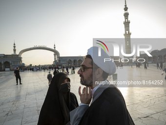 An Iranian veiled woman receives religious advices while speaking with a cleric as they arrive at Jamkaran's holy mosque to attend the Eid-a...