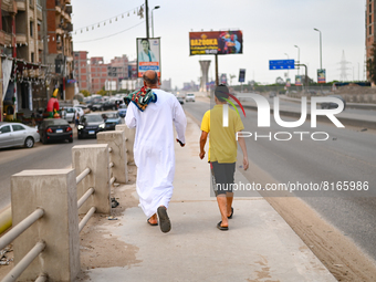 A man and his son in their way home after performing Eid prayers  ., on May 2, 2022, in Cairo, Egypt.  (