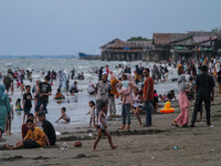 People are seen enjoying time on the beach during the Eid al-Fitr holiday at Ujong Blang Beach, Lhokseumawe, on May 4, 2022, Aceh Province,...