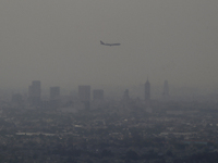 A plane flies overhead during the environmental contingency from Cerro de la Estrella in Iztapalapa, Mexico City.

The Environmental Commi...