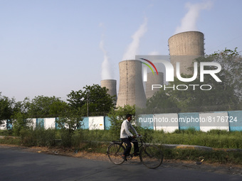A cyclist passes by the coal-fired thermal Power Plant of National Thermal Power Corporation (NTPC), at Dadri in Gautam Budh Nagar district,...