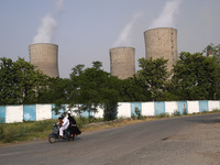 A scooterist passes by the coal-fired thermal Power Plant of National Thermal Power Corporation (NTPC), at Dadri in Gautam Budh Nagar distri...