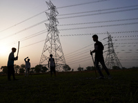 Children play near electricity transmission pylons of the coal-fired thermal Power Plant of National Thermal Power Corporation (NTPC), at Da...
