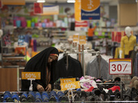 An Iranian woman looks on shoes while shopping in Tehran's Megamall on September 30, 2013. (
