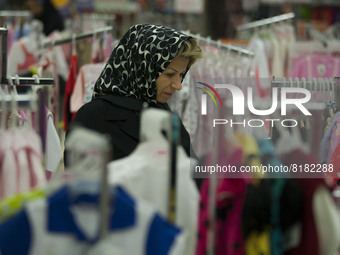 An Iranian woman walks through dresses while shopping in Tehran's Megamall on September 30, 2013. (