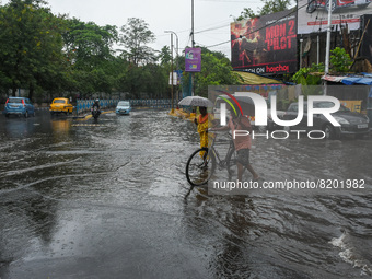 People are seen making there way through a waterlogged road after heavy rainfall due to effects of cyclone ASANI in Kolkata , India , on 9 M...