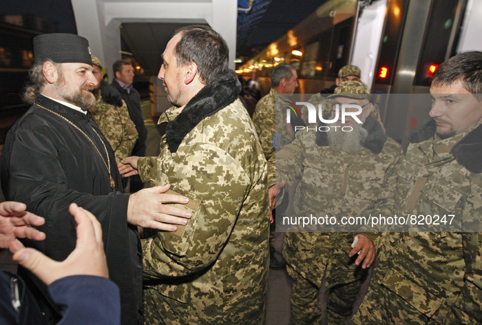 An Orthodox priest (L) say goodbye to priests of the Ukrainian Orthodox Church of Kiev Patriarchate wearing military uniforms during a being...