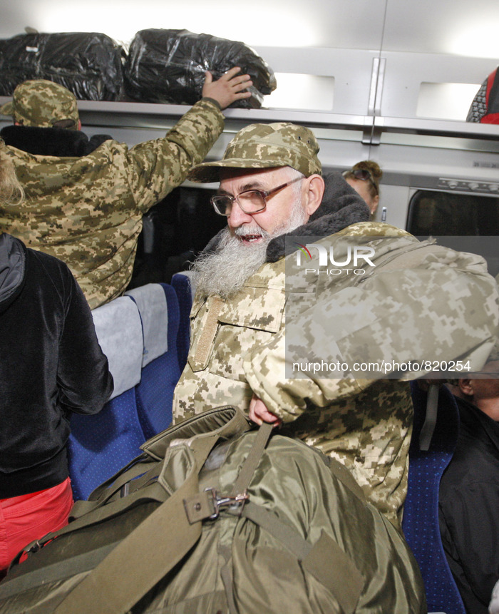 Priests of the Ukrainian Orthodox Church of Kiev Patriarchate wearing military uniforms take place in a train in Kiev on October 2, 2015, to...