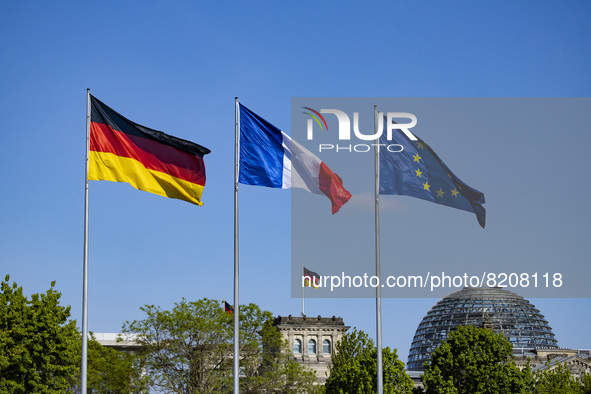 The German, French and European flags fly at the Chancellery in Berlin, Germany on May 9, 2022. 