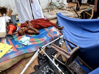 An anti-government Sri Lankan monk who got injured after being attacked by government supporters lies down  amid the destroyed tents infront...