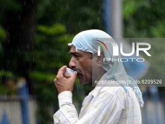 A man sips tea during rainfall in Kolkata, India, 10 May, 2022.  (